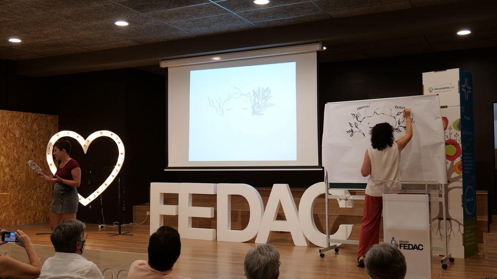 Les artistes Yèssica Ayala i Sílvia Morilla durant la seva creació conjunta de poesia i il·lustració en l'acte de comiat als educadors FEDAC jubilats.
