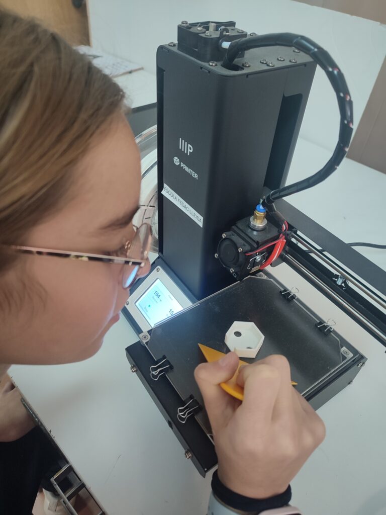 Una alumna d'educació se cundària de les escoles FEDAC fent una pràctica amb una impressora 3D.